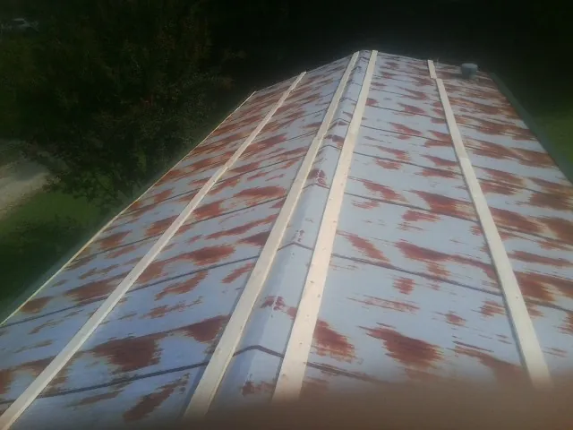Rusted metal roof panels with new wood purlins before replacement — Storm Damage Roof Repair in Leonardo by Roofing Brothers