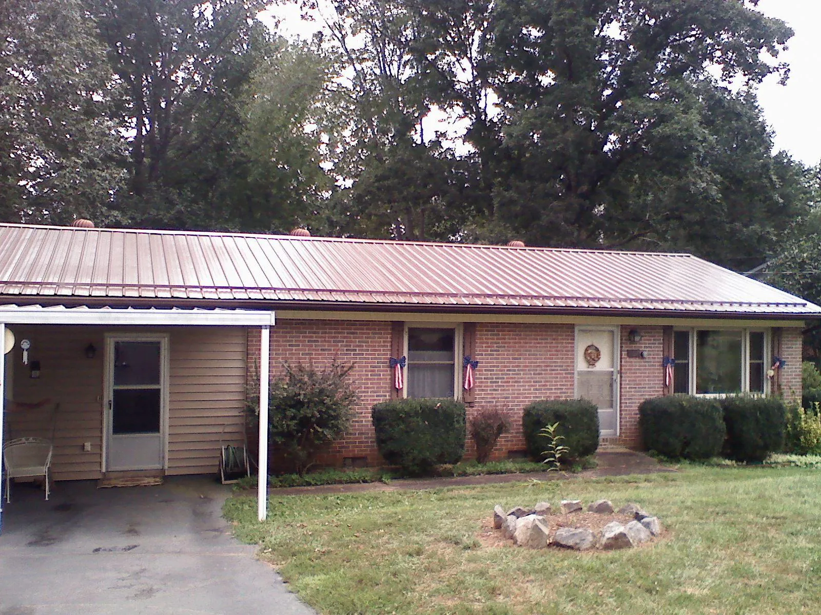Bronze metal roof and carport on a brick ranch home — Roof Repair work by our crew in Leonardo