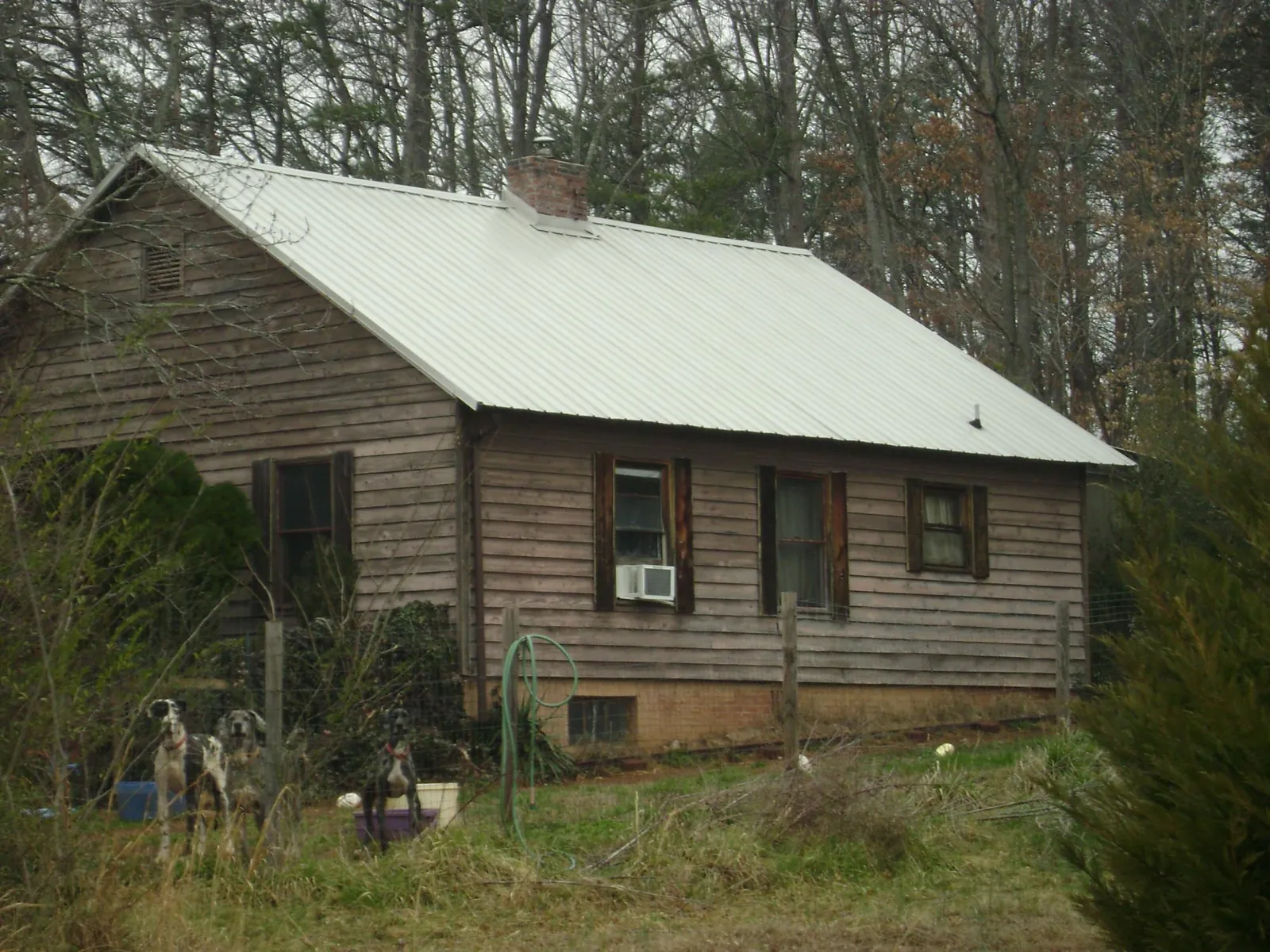 White metal roof on an old wood sided farmhouse, from a Metal Roof Installation job in Leonardo